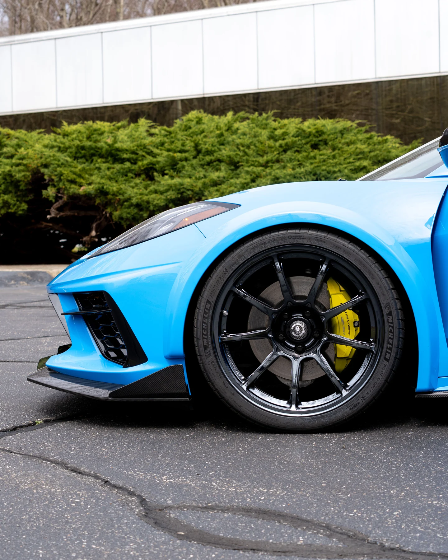 Black forged wheel beneath a carbon-fiber front fender flare